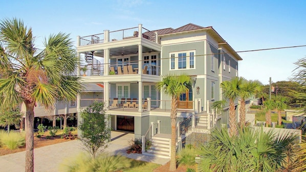 A two-story house with a balcony, a covered porch, and a staircase leading to the upper floor.
