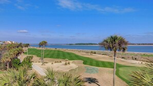 A golf course with a clear view of the ocean and a distant shoreline. - 322 D Shipwatch by Avantstay Community Pool Access & Close to Beach! (Isle of Palms)