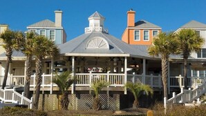 A coastal house with a covered porch, multiple balconies, and a white fence. - 322 D Shipwatch by Avantstay Community Pool Access & Close to Beach! (Isle of Palms)