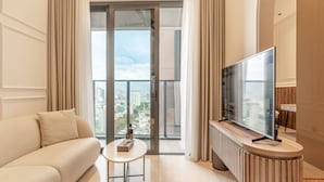 Una sala de estar moderna con un sofá, un televisor sobre un mueble de madera y una mesa con un control remoto.
