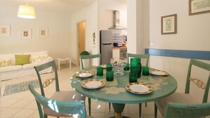 A dining area with a round table, chairs, and a hanging light fixture. - Villa Glicine by Interhome (Forte dei Marmi)