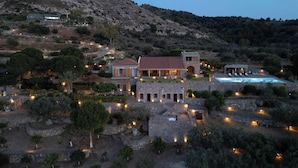 A large, stone villa with a swimming pool, surrounded by landscaped gardens and a mountainous backdrop. - Terra Cassa Private Villa (Aegina)