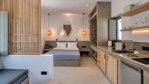 A modern bedroom with a bed, bedside tables, and a hanging light fixture. - Clementina Paros (Paros)