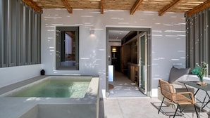 A modern outdoor area with a hot tub, a dining table with chairs, and a wooden ceiling. - Clementina Paros (Paros)