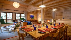 A wooden cabin with a dining area, a living room, and a kitchen. - Gorgeous, truly ski-in ski-out chalet with hot tub, sauna, fabulous views (Les Allues)