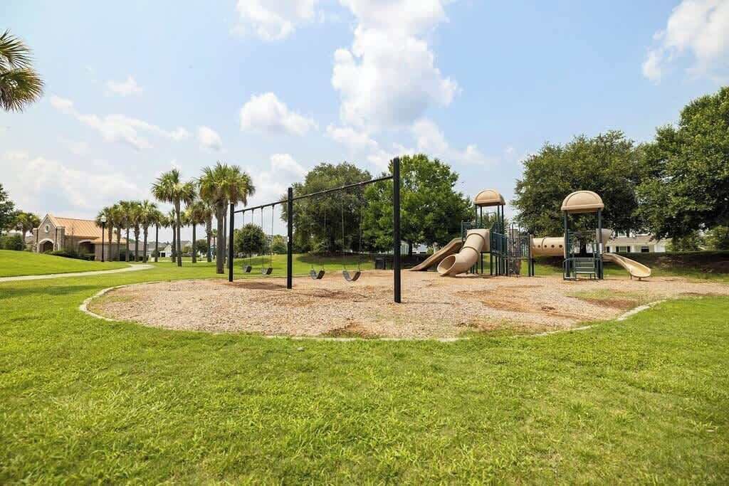 A playground with swings, a slide, and a climbing structure.