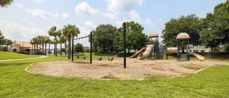 A playground with swings, a slide, and a climbing structure.