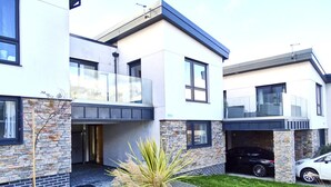 A modern two-story house with a stone facade, a garage, and a paved driveway. - Tolcarne - Perranporth Cornwall (Perranporth)