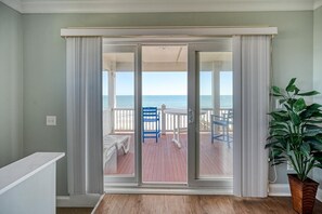 Et værelse med en skydedør, der fører ud til en balkon med havudsigt.