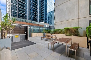 Sit and relax in a tranquil outdoor space with a seating area, planter, and city views.
