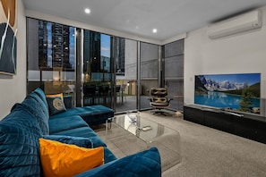 Relax in this stylish living room with a large sofa, coffee table, and flat-screen TV.