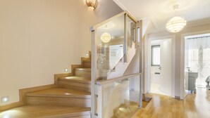 A modern staircase with glass railings and wooden steps leading to a second floor. - Something special in Chalkida - 300 m from the seafront (Xirovrisi)