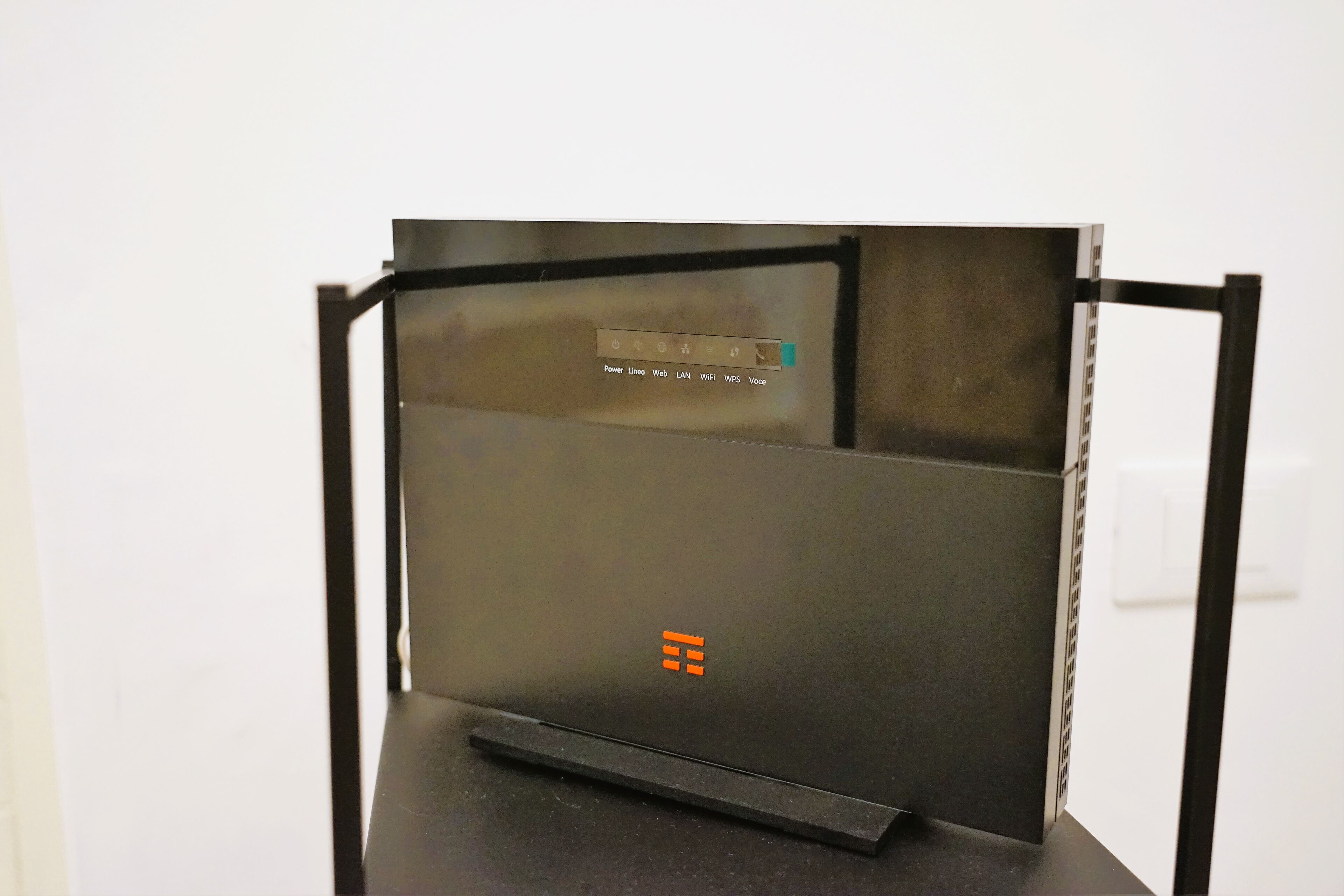 Una computadora portátil con teclado negro y panel táctil, mostrando un icono de encendido y un símbolo de Wi-Fi.