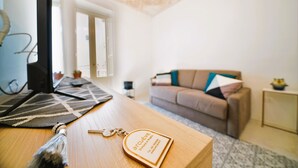 Ein modernes Wohnzimmer mit einem Holztisch, einem Laptop und einem dekorativen Schlüsselanhänger.