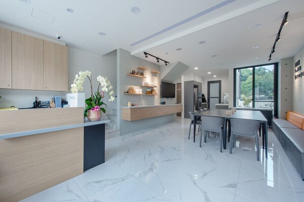 A modern kitchen with marble flooring, wooden cabinets, and a central island. - Nicewalk B&B (Yuchi)