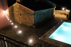 Relax by the pool under the stars, surrounded by a serene atmosphere.