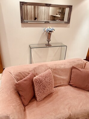 Relax in this stylish living room with a plush sofa, console table, and ornate mirror.
