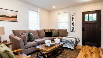 A living room with a brown sofa, a wooden coffee table, and a patterned rug.