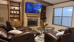 A living room with leather recliners, a flat-screen TV, a fireplace, and a large window. - Cozy, spacious & convenient home-3bedrooms 3baths (Pasadena)