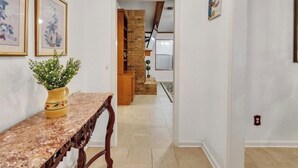 A hallway with a marble table, a potted plant, and framed artwork on the wall. - Cozy, spacious & convenient home-3bedrooms 3baths (Pasadena)