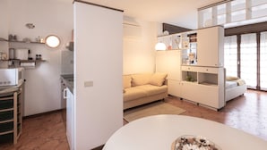 A compact kitchen with a built-in oven, a dining table, and a sofa. - Casa Saronni by Wonderful Italy (Bellagio)
