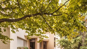 A building with a stone staircase leading to a door, surrounded by greenery and a small garden area. - Casa Saronni by Wonderful Italy (Bellagio)