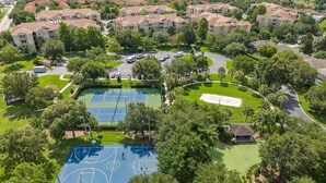 Eine Vogelperspektive zeigt eine Wohngegend mit mehreren Wohngebäuden, einem Tennisplatz und einem Golfplatz.