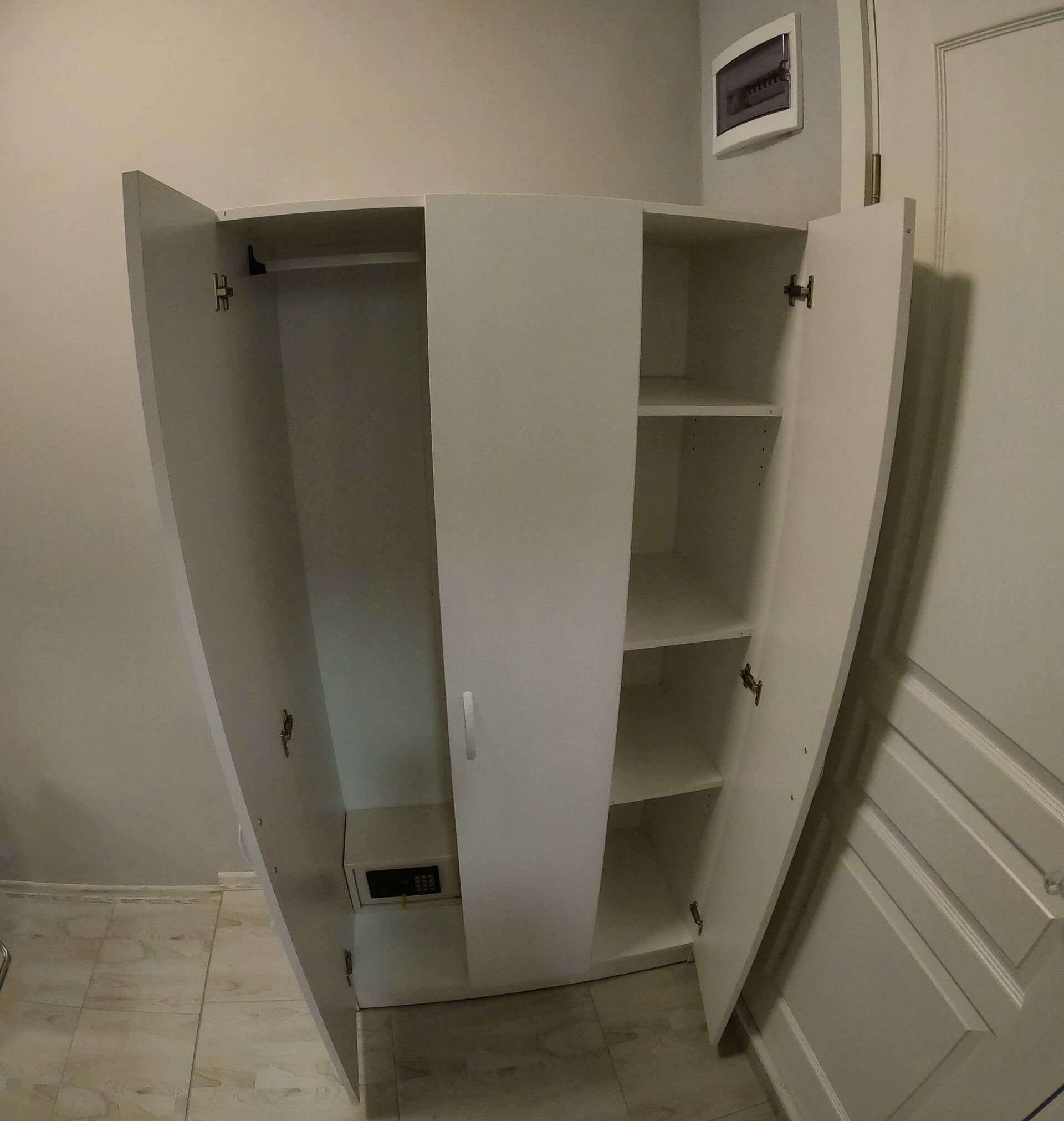 A white walk-in closet with multiple shelves and a small compartment.