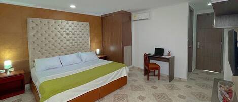 A hotel room with a bed, a desk, and a wardrobe.