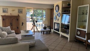 A living room with a sofa, a telescope, a cabinet, and a bookshelf. - Beach house (La Seyne-sur-Mer)