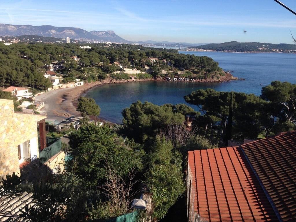 A coastal view with a beach, buildings, and a mountain in the background.