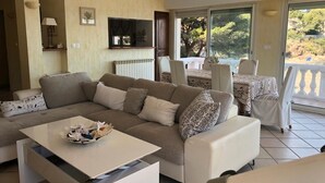 A living room with a sofa, coffee table, and a dining area with a table and chairs. - Beach house (La Seyne-sur-Mer)