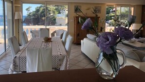A dining area with a table set for four, a sofa, and a vase with flowers. - Beach house (La Seyne-sur-Mer)