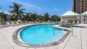 A pool area with a 3 FT no diving sign, lounge chairs, and palm trees. - Elaborate Beachfront Condo | Rooftop Pool/Spa (Marco Island)