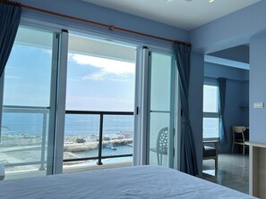 Quarto quádruplo luxo, várias camas, vista para o mar | Escrivaninha, espaço de trabalho para notebook, cortinas blackout