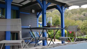 Un patio al aire libre con mobiliario azul y blanco, una mesa y sillas.