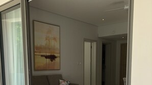 A modern living room with a sofa, a coffee table, and a dining area with a table set for two.