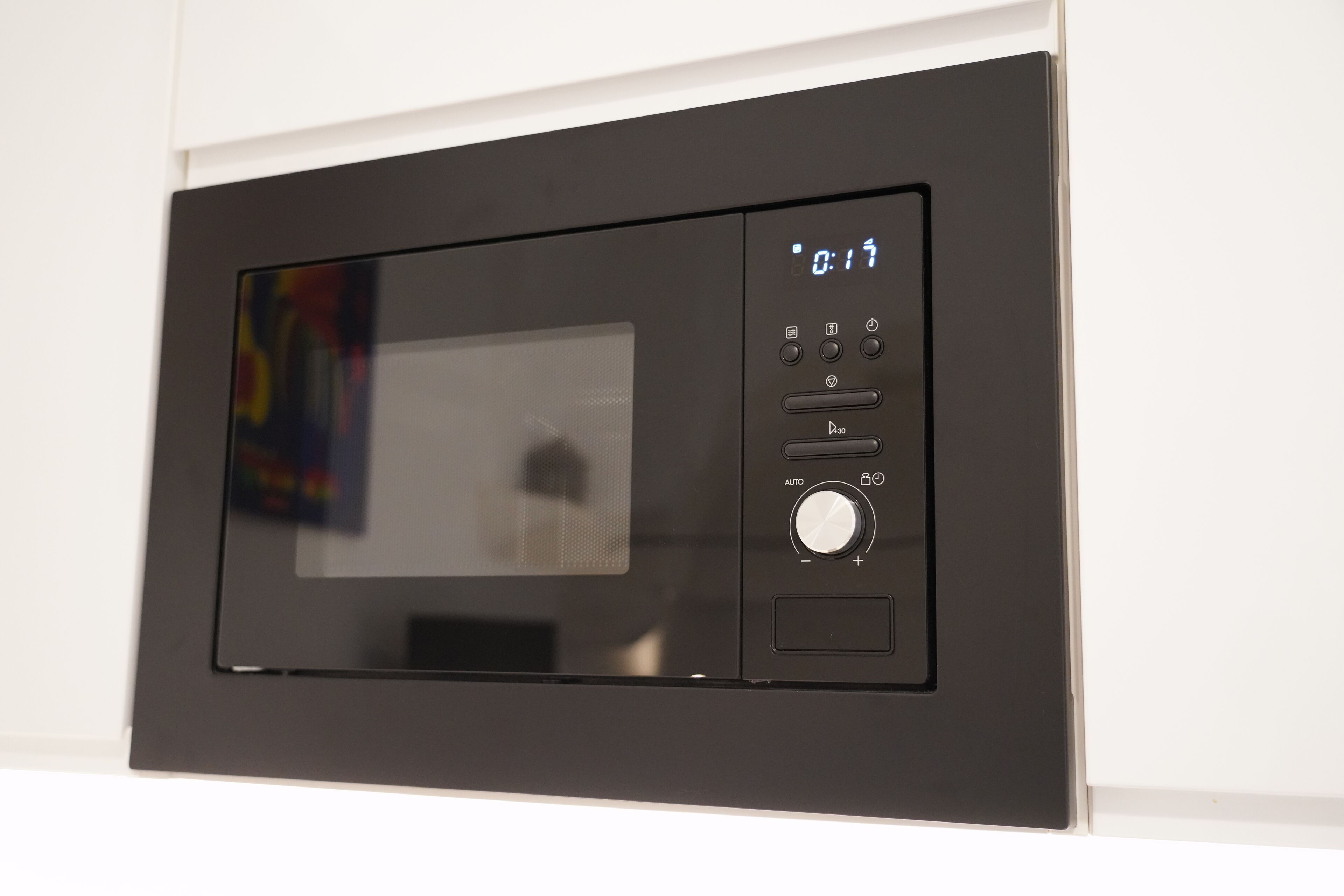 Un microondas moderno con pantalla digital y panel de control.