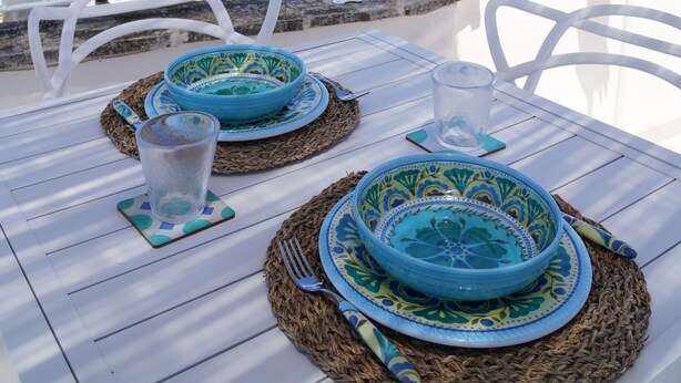 Una terraza con una mesa dispuesta para dos, con vistas al mar.