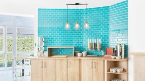 A modern kitchen with light wood cabinets, a teal brick backsplash, and a breakfast bar. - Lorelei Pension Adults Only (Gyenesdias)