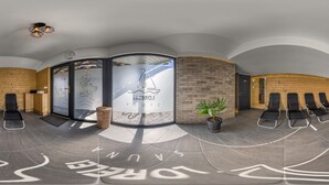 A modern spa with a curved ceiling, black lounge chairs, a reception area, and a visible logo on the wall. - Lorelei Pension Adults Only (Gyenesdias)