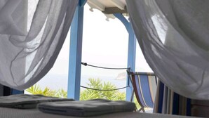 A bed with white sheets and a view of the ocean through sheer curtains. - Cases créoles classified 4**** with private pools (Terre-de-Bas)