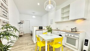 A modern kitchen with a dining table, chairs, and a microwave. - Mejorana Apartament (1 bedroom apartment) (Madrid)