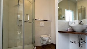 Une salle de bain moderne avec une douche à parois de verre, des toilettes et un lavabo avec un miroir.