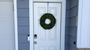 A white door with a green wreath, a mailbox, and a black mat at the entrance. - The Badger House ~ Rib Mtn Ski~ (Wausau)