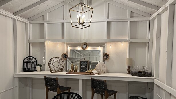 A dining area with a wooden table, two chairs, a hanging light fixture, and a mirror above the counter. - Remodeled Riverside Cottage w/sunroom, She-shed. Walk to golf, tennis, Botanica, (Wichita)
