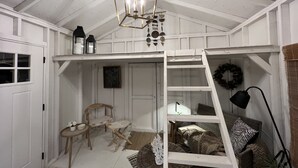 A cozy room with a loft bed, a ladder, a small table, and a chair. - Remodeled Riverside Cottage w/sunroom, She-shed. Walk to golf, tennis, Botanica, (Wichita)
