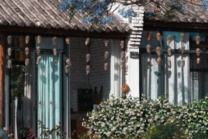 A traditional building with a tiled roof, a wooden door, and a window with a curtain. - Perch House (Dali City)