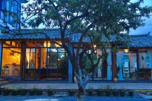 A traditional building with a tiled roof, large windows, and a wooden deck. - Perch House (Dali City)