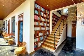 A library with bookshelves and a staircase. - Perch House (Dali City)